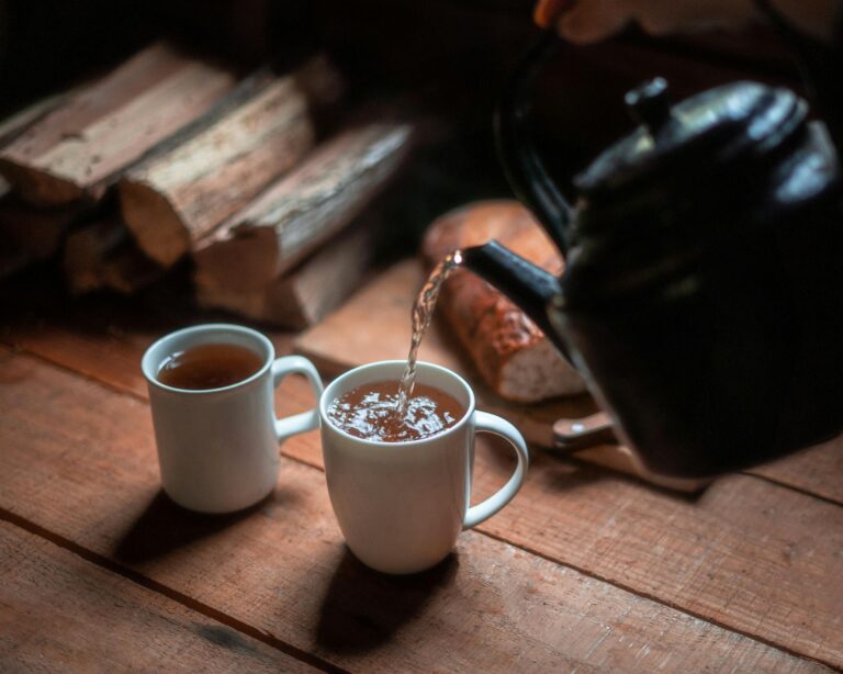 Repair checklist A cozy rustic scene of tea being poured into white mugs, perfect for relaxation.
