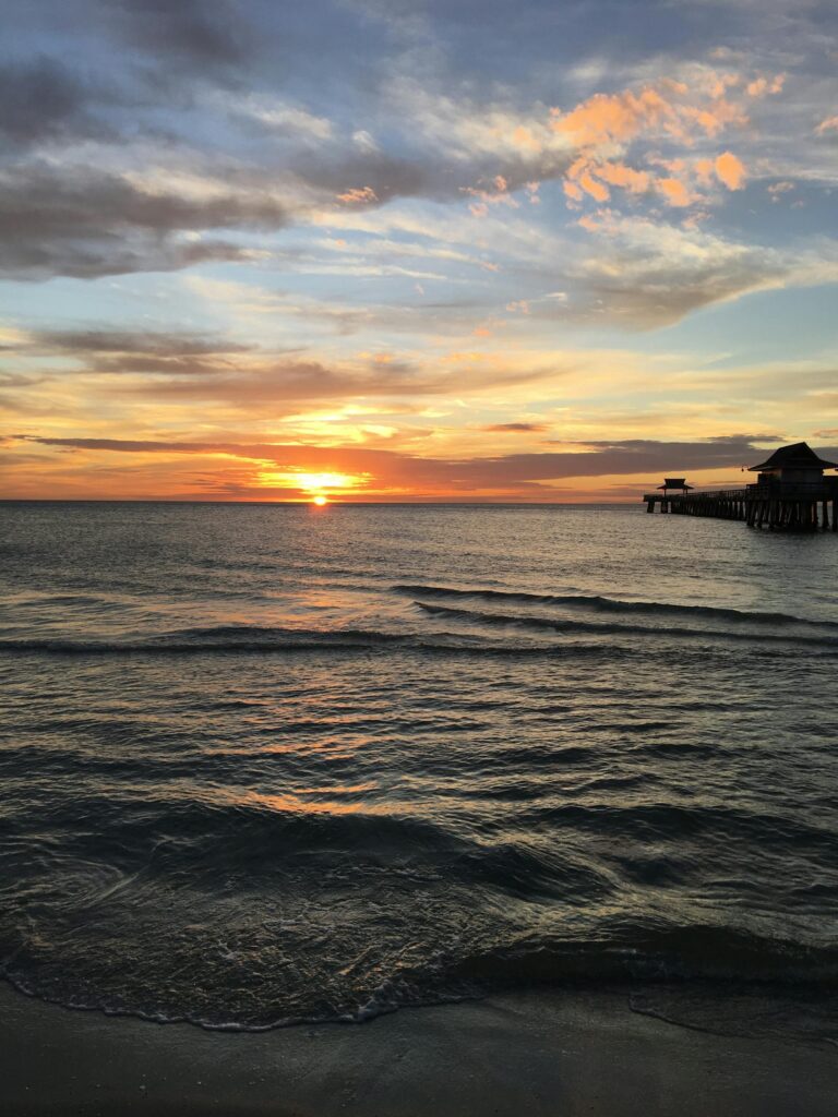 Beautiful sunset over the Gulf of Mexico at Naples Pier, Florida.
