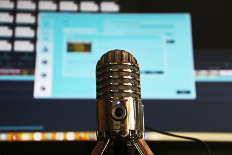 neurodiverse podcast Close-up of a microphone with a blurred computer screen in the background, ideal for podcast themes.