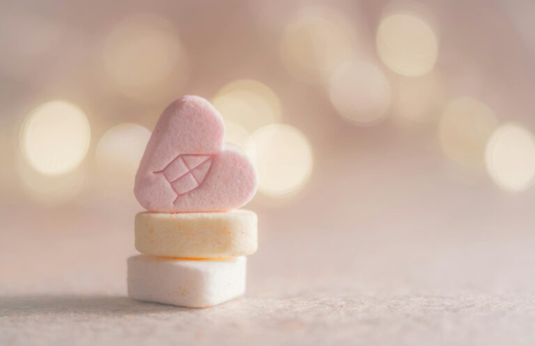 Close-up of heart-shaped candy with a warm bokeh background, perfect for holiday themes.