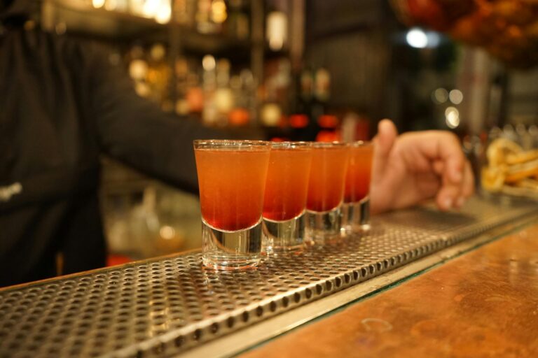 Colorful cocktail shots ready on a bar counter, capturing nightlife and bar atmosphere.