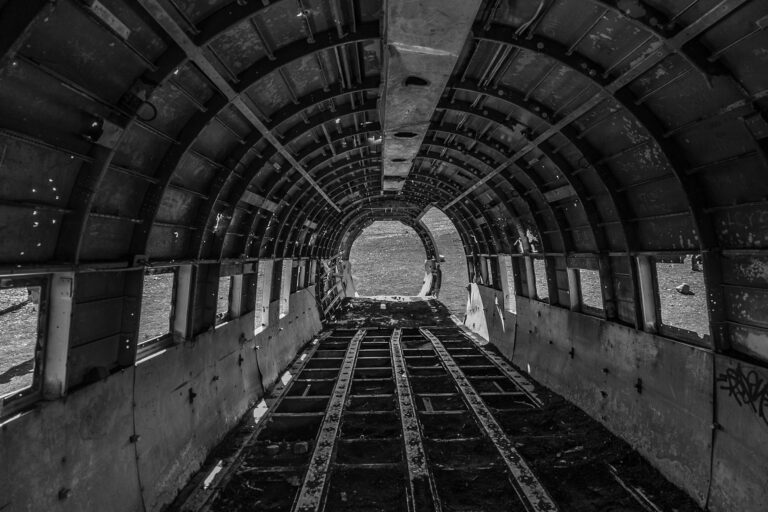 Explore the haunting interior of an abandoned aircraft wreckage in monochrome.