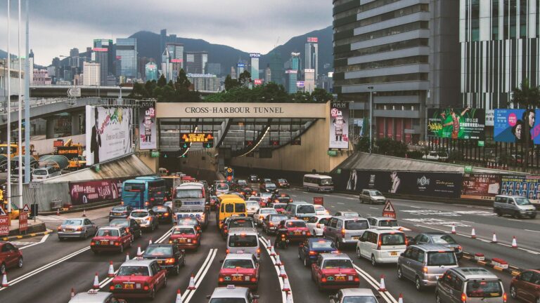 Heavy traffic congestion at Hong Kong's Cross-Harbour Tunnel with cityscape.