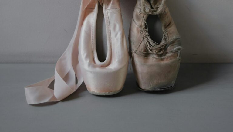 New and used ballet pointe shoes showing wear and elegance in a studio setting.