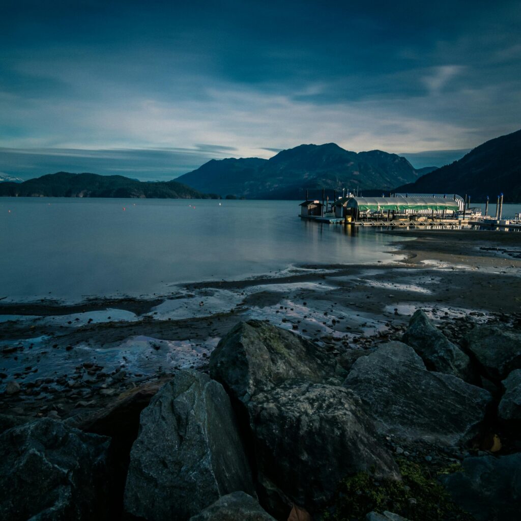 Peaceful dawn at Harrison Hot Springs with a serene view of the lake and mountains.