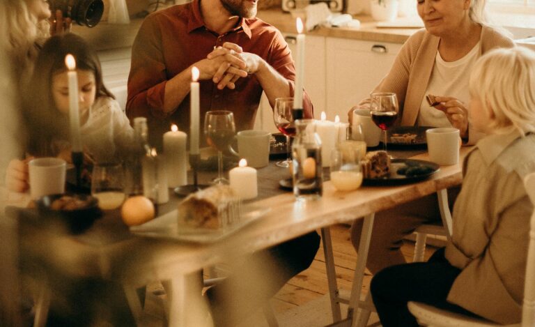 Family enjoying a warm holiday dinner together with candles and laughter.
