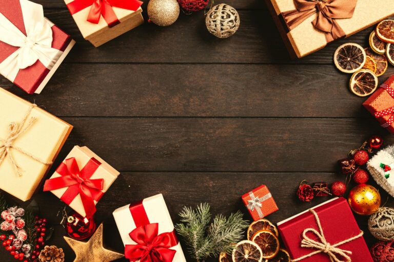 Top view of Christmas gifts and decorations on a wooden table, ideal for holiday backgrounds.